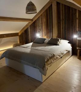 een slaapkamer met een groot bed en houten wanden bij Chalet Hoge Kempen in Zutendaal