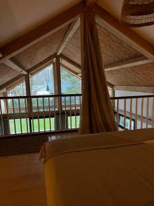 a bedroom with a bed and a large window at Chalet Hoge Kempen in Zutendaal