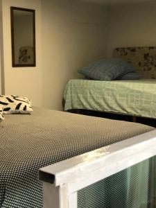 1 dormitorio con 2 camas y espejo en Residencial Estrela Dalva- 450 metros do mar, en Florianópolis