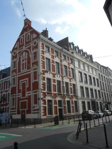 een groot rood-wit gebouw in een stadsstraat bij Appartement Chaleureux en Hyper Centre à Lille in Lille
