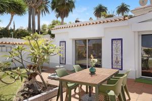 a wooden table and chairs in front of a house at House Experience Villa Violeta in La Victoria de Acentejo