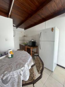 Keila's Apartment في كونكورديا: مطبخ مع طاولة وثلاجة بيضاء