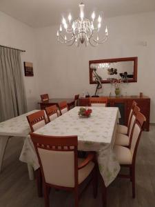 uma sala de jantar com uma mesa com cadeiras e um lustre em Apartamento frente al Mar para 7 em Pinamar