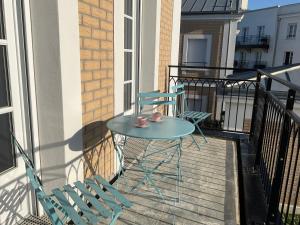 einen blauen Tisch und zwei Stühle auf dem Balkon in der Unterkunft Sunny apartment near Disneyland Paris – Liz Appart in Serris