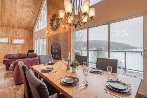 una sala da pranzo con tavolo e una grande finestra di Rustic Waterfront Chalet Panoramic View and Spa a Chertsey