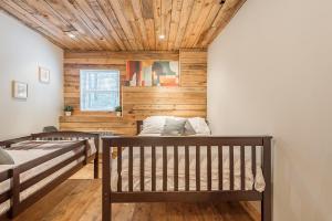 una camera con 2 letti e un soffitto in legno di Rustic Waterfront Chalet Panoramic View and Spa a Chertsey