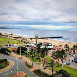 a view of a beach with a pier and cars at NO: 75 WINDEMERE HOLIDAY FLAT in Durban