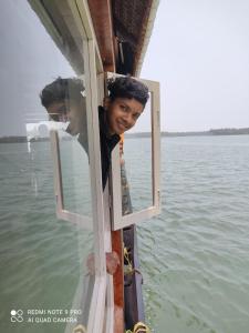 a young boy looking out the window of a boat at Ezhimala cruise in Nīleshwar