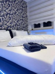 - un lit blanc avec 2 serviettes bleues dans l'établissement apartment ALUB, à Bischofshofen