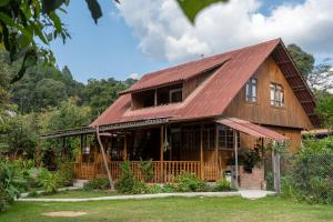 a wooden house with a red roof at Carolina Egg Gasthaus in Oxapampa