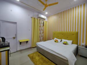 a bedroom with a bed with two stuffed animals on it at Yellow Inn Guest House in Lucknow