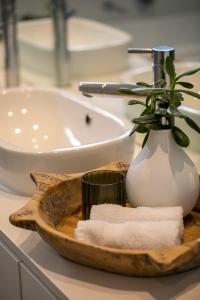 - un lavabo dans la salle de bains avec un plateau en bois, des serviettes et un vase dans l'établissement Luxury Norwood Retreat, à Kensington and Norwood