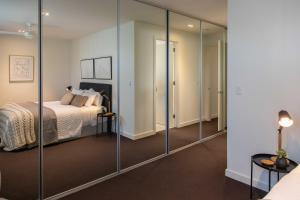 - une chambre avec des portes coulissantes en verre et un lit dans l'établissement Luxury Norwood Retreat, à Kensington and Norwood