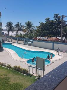 una piscina con gente jugando en ella en COBERTURA Duplex com vista do Mar, Condomínio Village das ondas, en Piúma