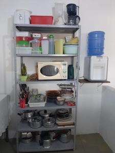 a shelf with dishes and a microwave in a kitchen at Casa Paraty in Paraty +10 photos