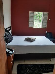 a bed in a room with a red wall at Casa Paraty in Paraty