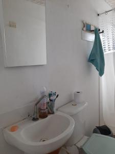 a bathroom with a white sink and a toilet at Casa Paraty in Paraty
