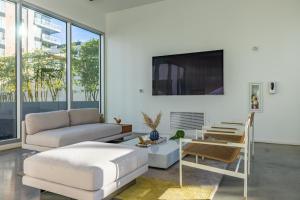a living room with a couch and a tv at @ Marbella Lane - Grand 2BR w/ Beach & Ocean Views in Long Beach