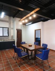 a dining room with a table and blue chairs at INTI 0 in San Antonio de las Alzanas