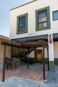 - un bâtiment avec une terrasse couverte et un banc devant dans l'établissement INTI 0, à San Antonio de las Alzanas