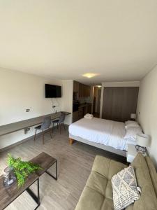 um quarto de hotel com uma cama, um sofá e uma mesa em Central Vip Antofagasta em Antofagasta