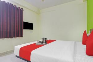 a bedroom with a white bed with a red and white blanket at Super OYO Dk Reddy Square in Hyderabad