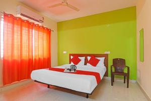 a bedroom with a bed with red and green walls at Super OYO Dk Reddy Square in Hyderabad