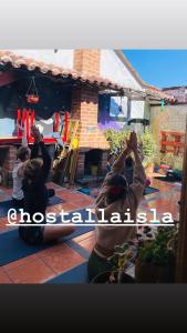 聖克里斯托瓦爾－德拉斯卡薩斯的住宿－Hostal La Isla，一群人在房子前做瑜伽