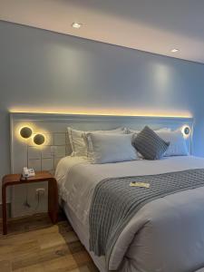 a bedroom with a large bed with a blue headboard at Carballo Hotel & Spa in Campos do Jordão