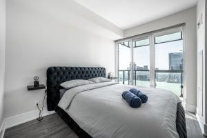 a bedroom with a large bed with a large window at Luxury Condo w/Mesmerizing Sunset Views & FREE Parking in Toronto