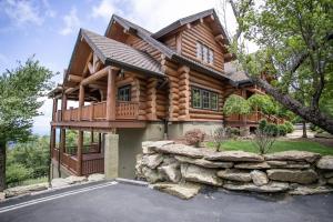 a log cabin house with a stone wall at Mansion In The Sky in Beech Mountain