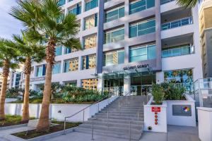 a building with palm trees in front of it at @ Marbella Lane - Grand 2BR w/ Beach & Ocean Views in Long Beach