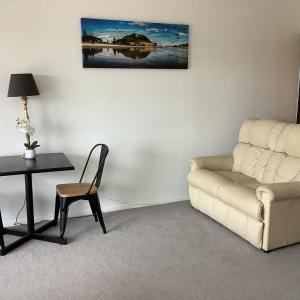 uma sala de estar com um sofá e uma mesa em Botanical Haven BnB em Tauranga