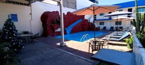 a patio with a christmas tree and a swimming pool at Hotel Confort Plaza in Culiacán