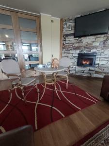 a living room with a table and chairs and a fireplace at Visok B&B in Frutillar