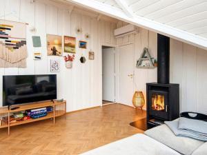 ein Wohnzimmer mit einem Kamin und einem TV in der Unterkunft Holiday home Fårvang VII in Fårvang