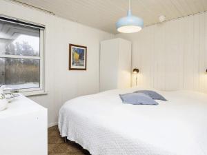 ein Schlafzimmer mit einem weißen Bett und einem Fenster in der Unterkunft Holiday home Løkken IV in Løkken