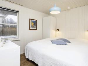 a bedroom with a white bed and a window at 6 person holiday home in Løkken-By Traum in Løkken