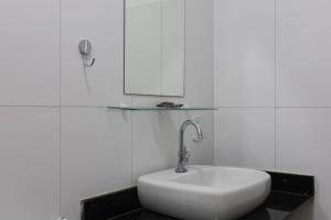 a white sink in a bathroom with a glass shelf at Suítes Praia dos Anjos - Arraial do Cabo in Arraial do Cabo +37 photos