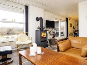 a living room with a couch and a fireplace at 6 person holiday home in Løkken-By Traum in Løkken