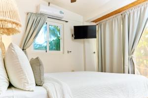 a bedroom with a white bed and a window at Aaki Hotel in Las Peñitas