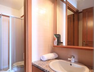 y baño con lavabo, aseo y espejo. en Appartamento 50 mq in Palace Ponte di Legno, en Ponte di Legno