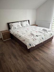 1 cama en un dormitorio con suelo de madera en Vila Mishela, en Berovo