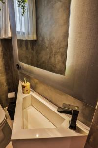 ein Bad mit einem Waschbecken und einem Spiegel in der Unterkunft Apartamento Com Vista Para o Mar in Balneário Camboriú