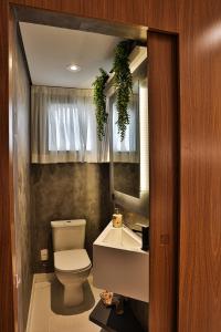 ein Badezimmer mit einem WC, einem Waschbecken und einem Spiegel in der Unterkunft Apartamento Com Vista Para o Mar in Balneário Camboriú