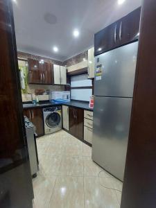 a kitchen with a stainless steel refrigerator and a dishwasher at Luxurious vip apartment in Cairo