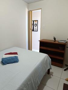 1 dormitorio con cama blanca y vestidor en Duplex com dois Quartos en Salvador