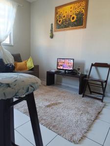 a living room with a couch and a tv on a table at Duplex com dois Quartos in Salvador