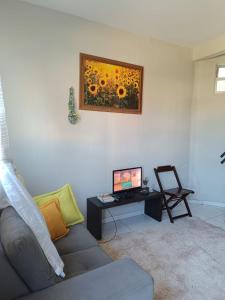 sala de estar con sofá y mesa con ordenador en Duplex com dois Quartos, en Salvador