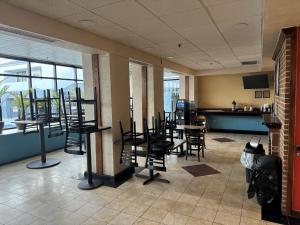 a waiting room with chairs and tables in a restaurant at Inn & Suites at Fort Gregg-Adams in Prince George